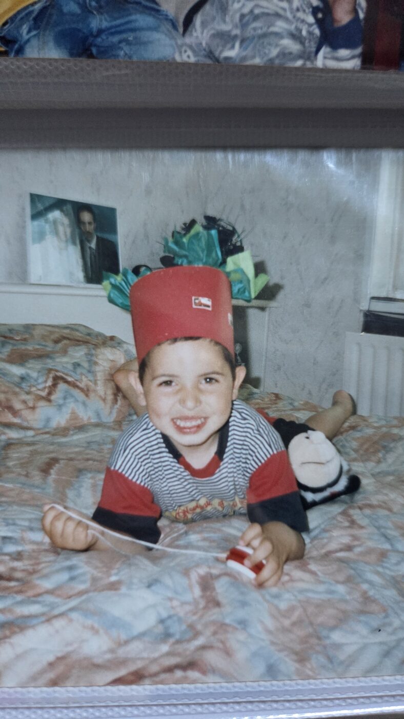 Mustafa with red hat on bed